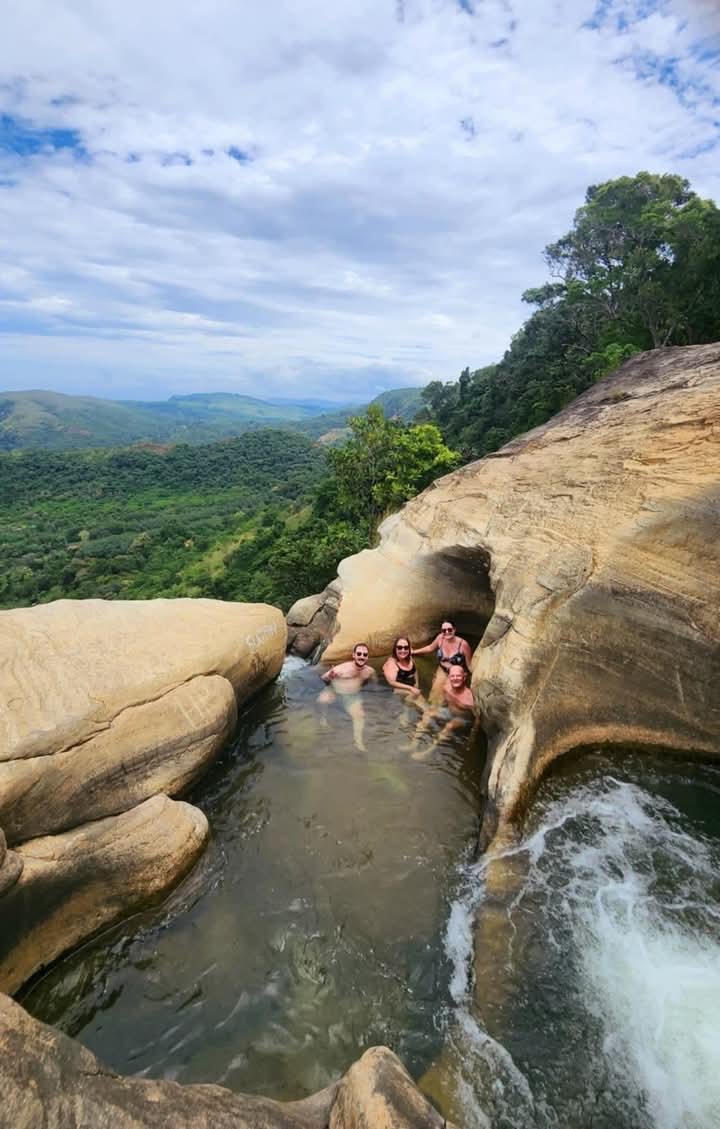 Travellers swimming beside a waterfall